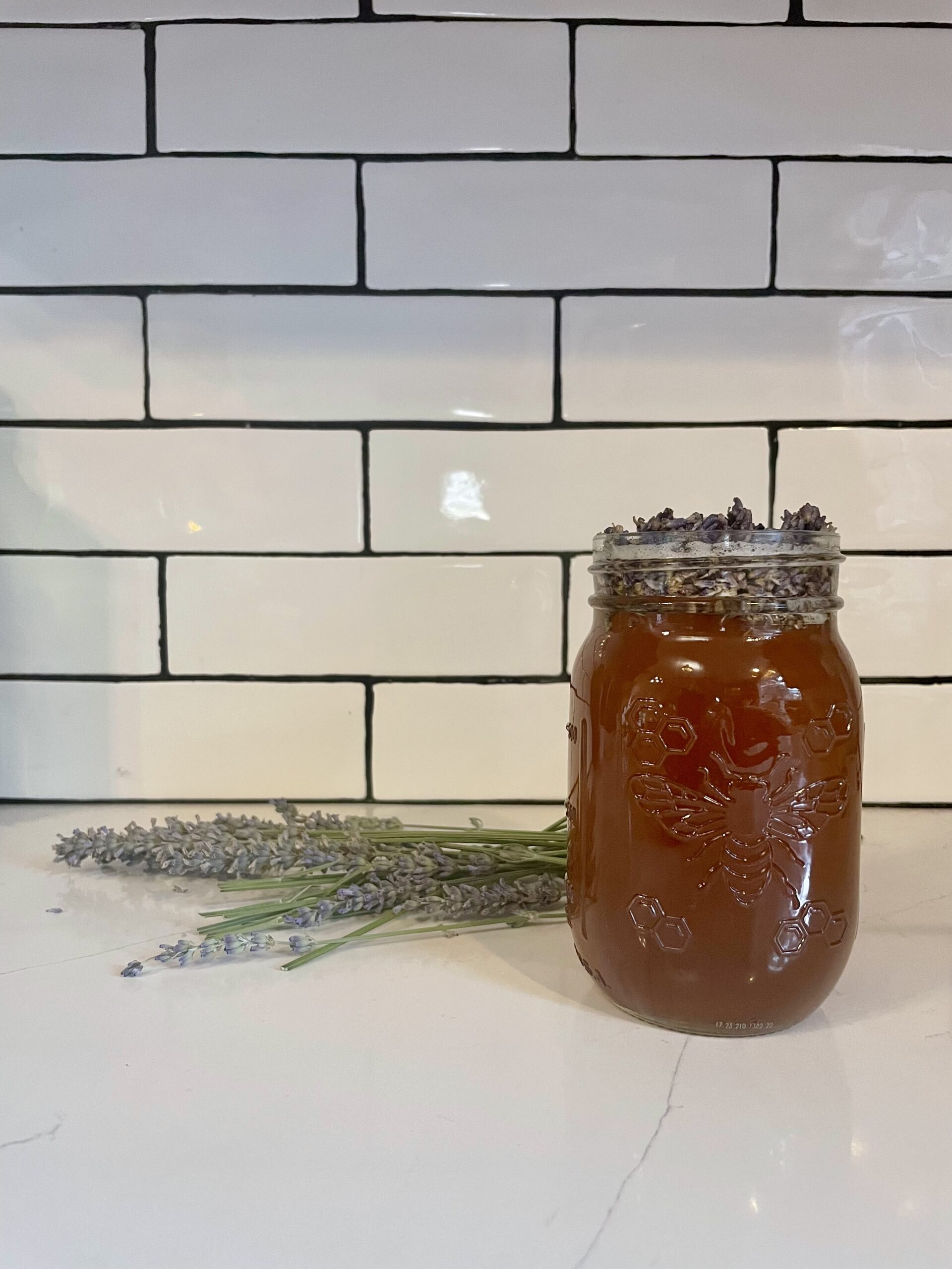 Image of Mason jar of lavender honey simple syrup with lavender sprigs and buds