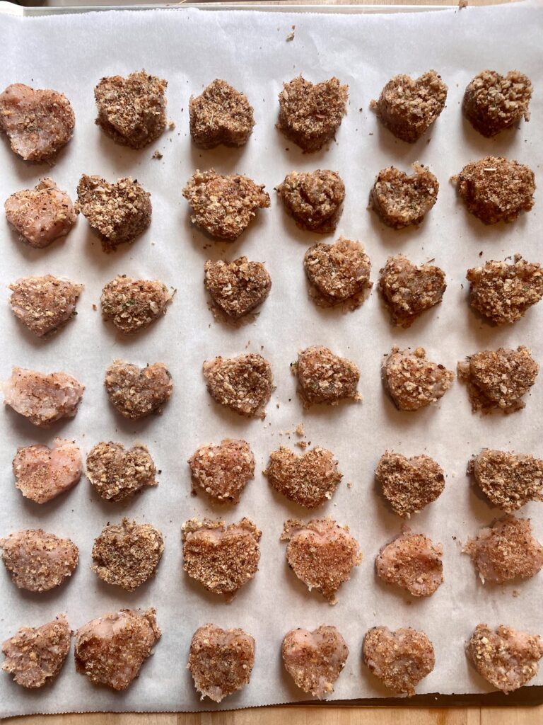 image of chicken nuggets lined on a baking sheet with parchment paper