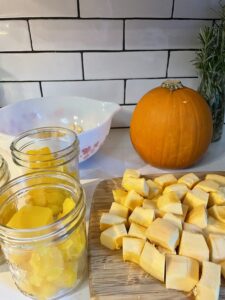 homemade pumpkin puree prep with pumpkin cubed and in jars