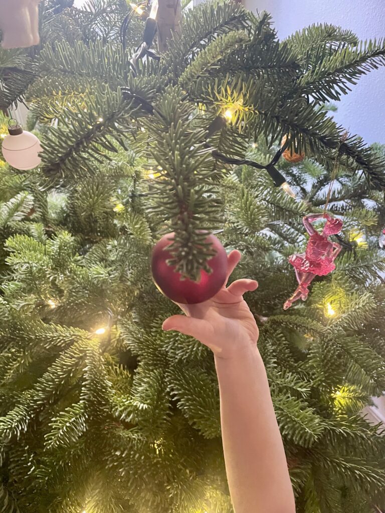 image of child holding a Christmas Ornament